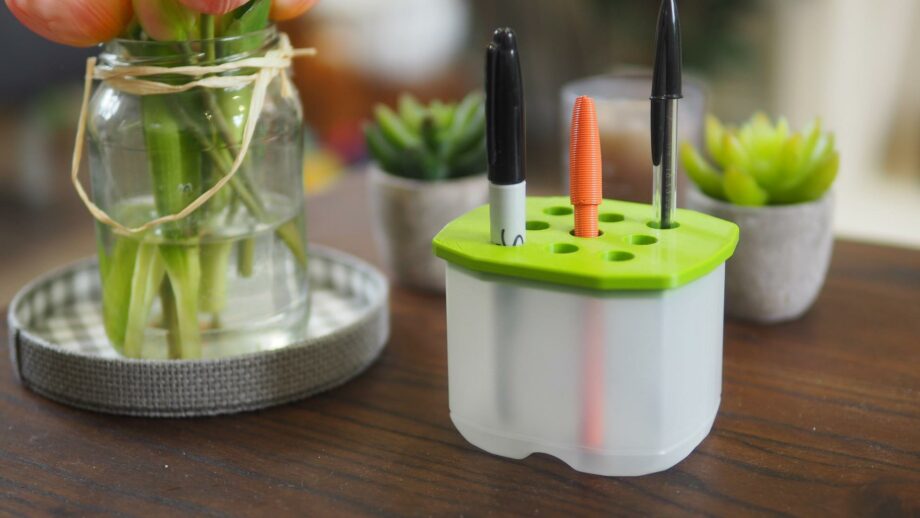 3D printing pen holder lid inserted into a waste packaging container. 3 pens sit within the holder.