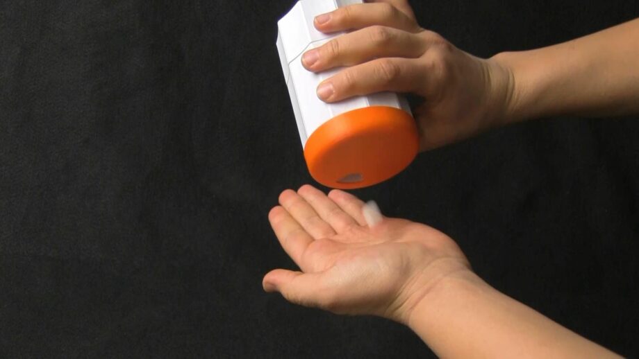 Person dispensing a pill out of a 3D printed pill dispenser.