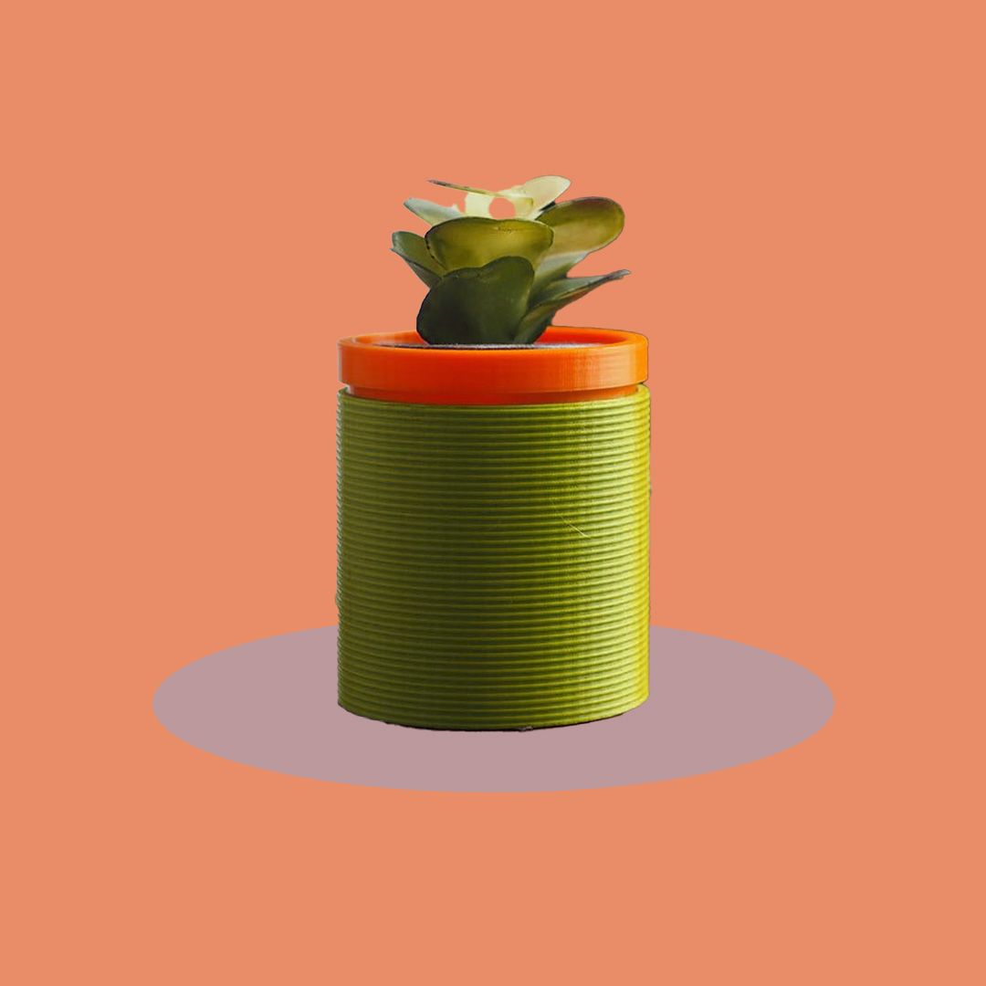 A 3D printed self-watering planter with a small plant inside.